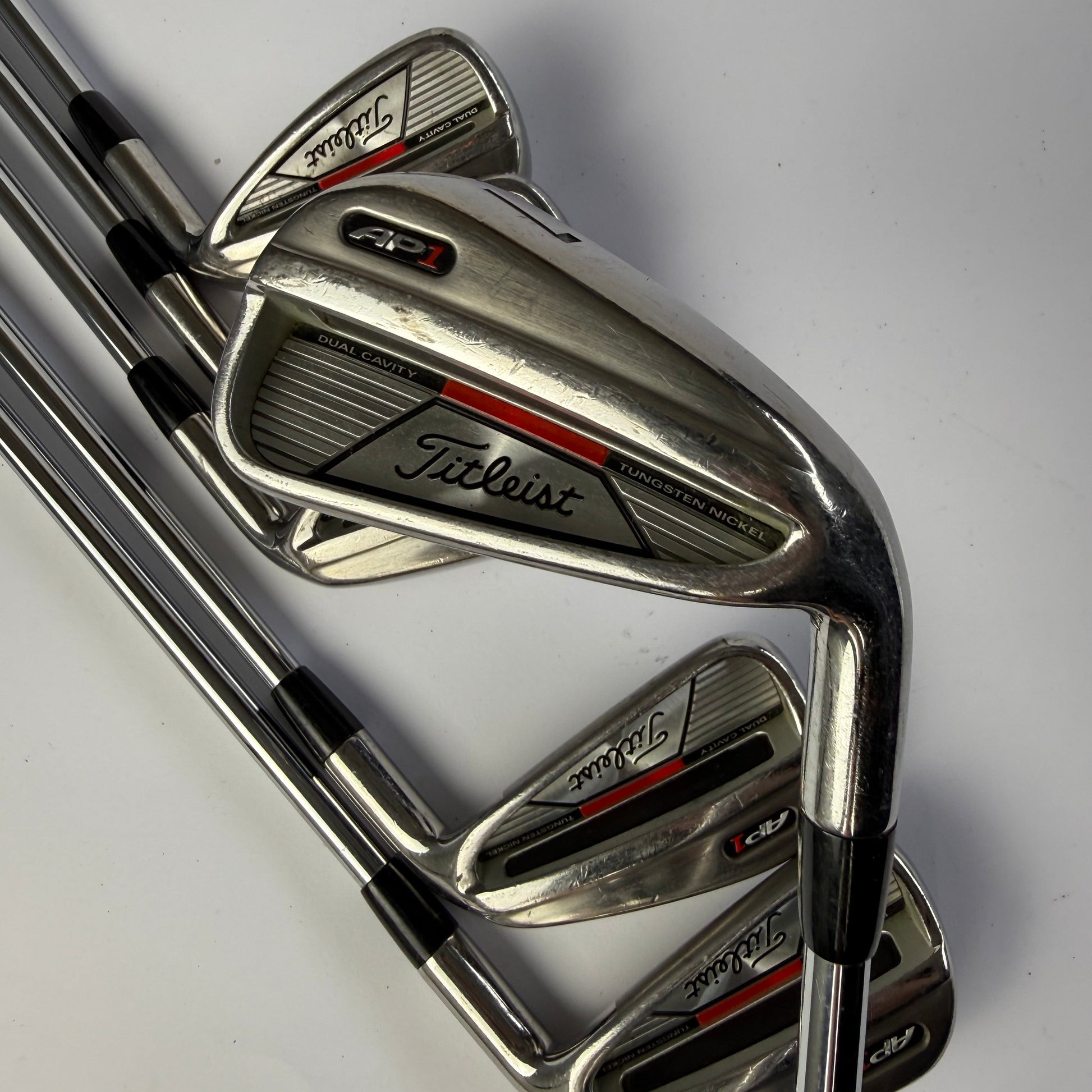 Set of golf clubs with Titleist AP1 branding on a white background