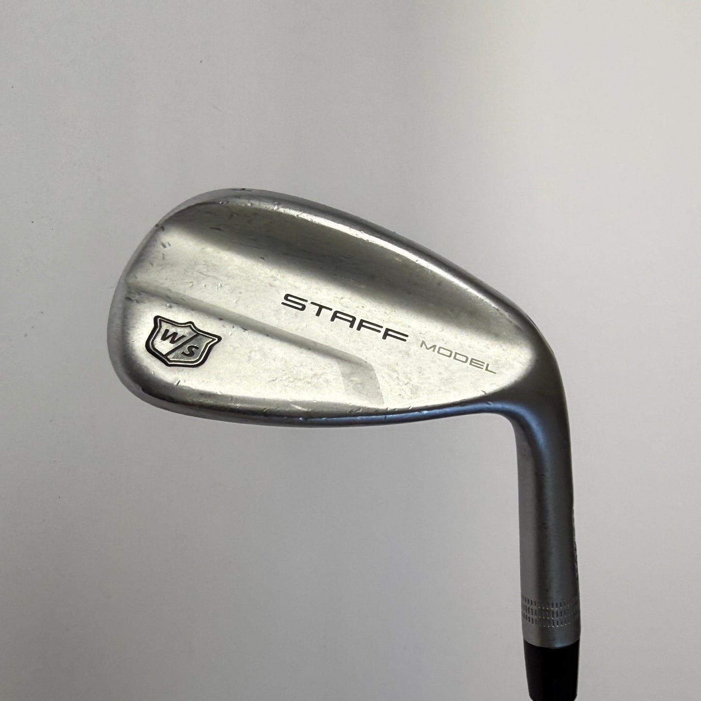Wilson Staff wedge golf club on a gray background