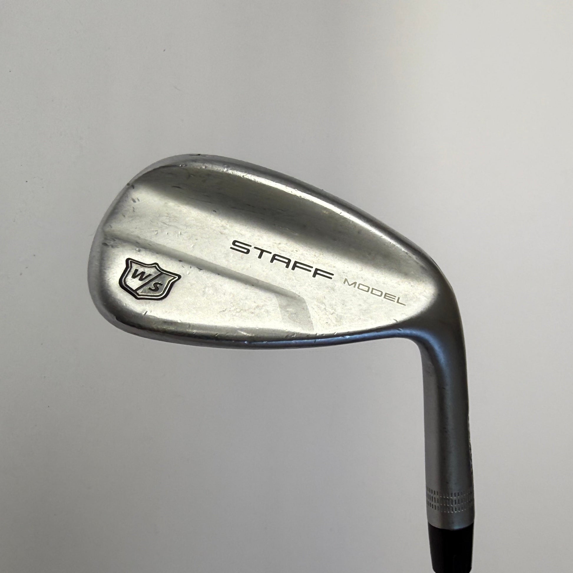 Wilson Staff wedge golf club on a gray background