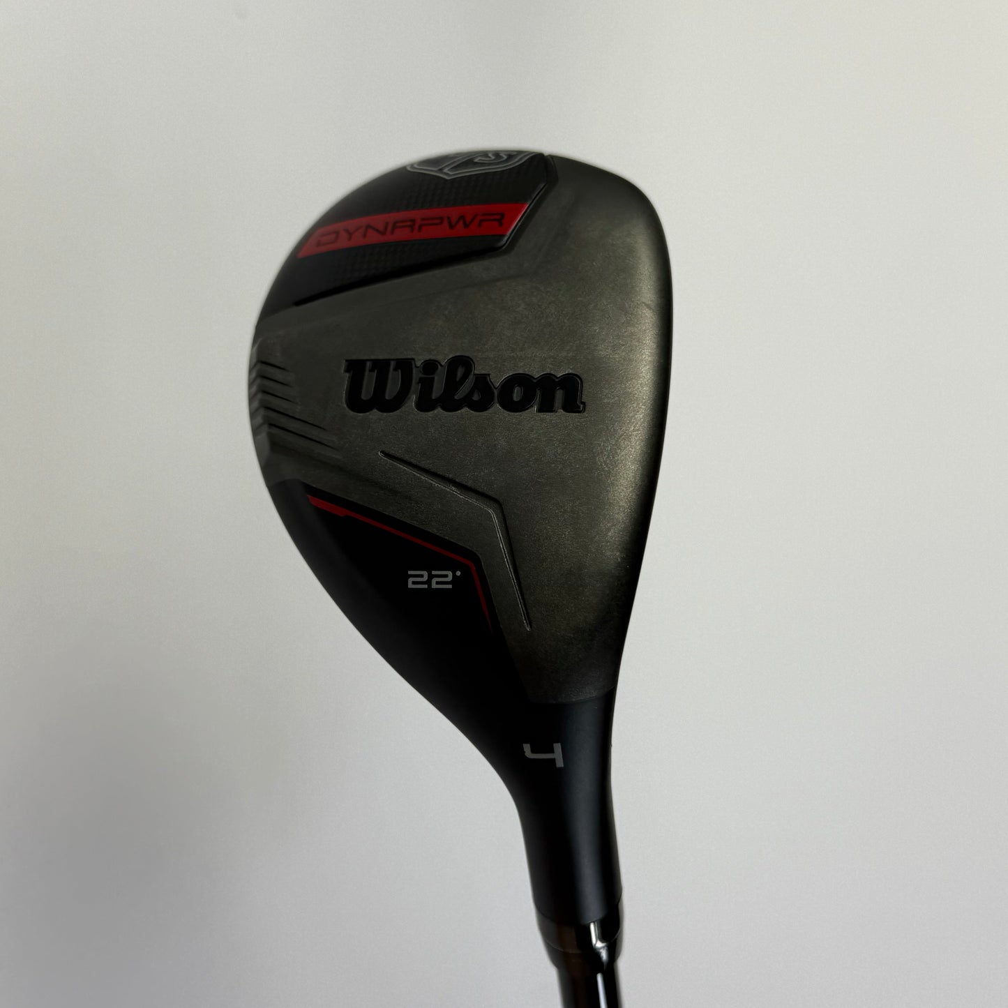 Hybrid golf club with 'Wilson Staff Dynapower' branding on a light gray background
