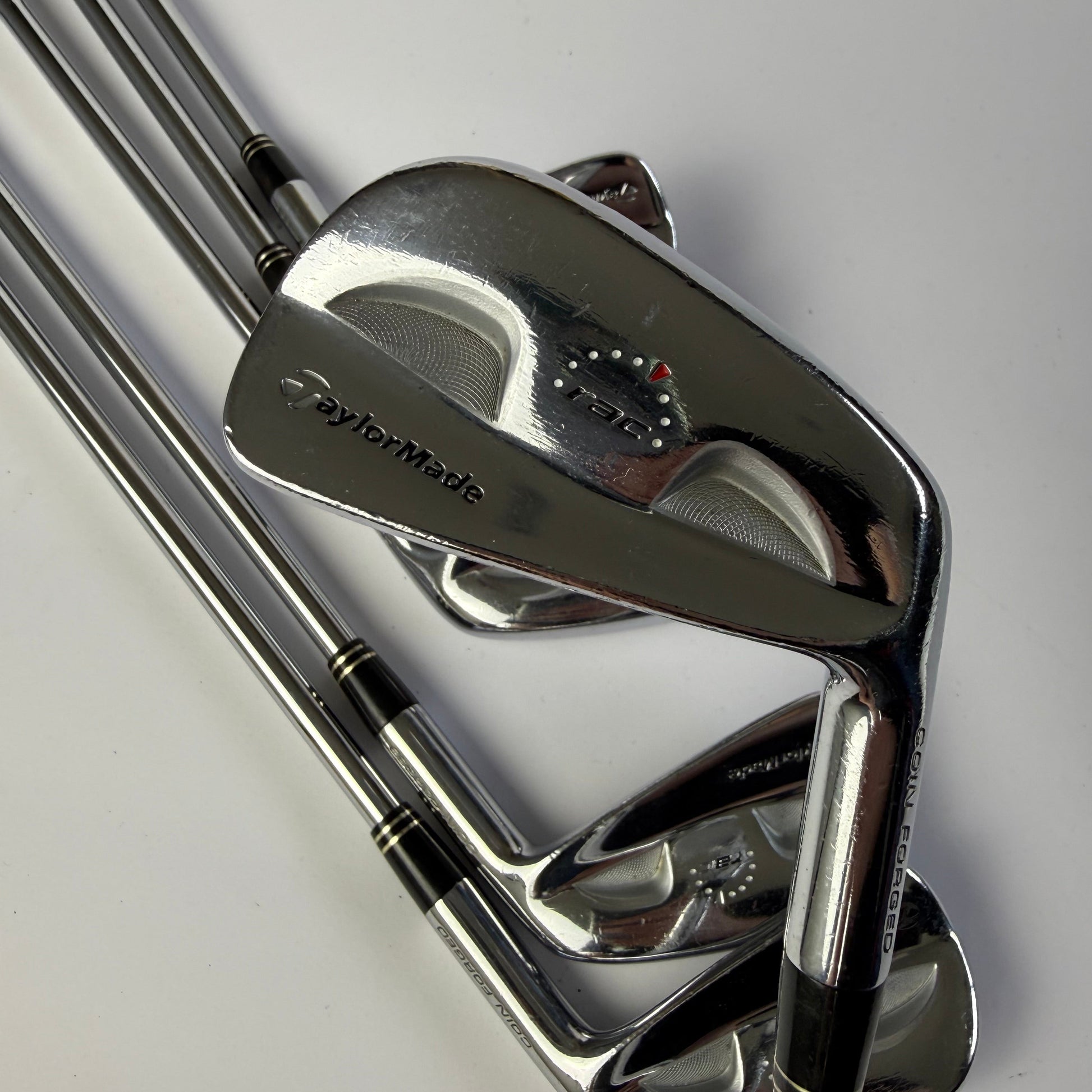 Taylormade RAC Coin Forged Blade Irons golf club set on a white background