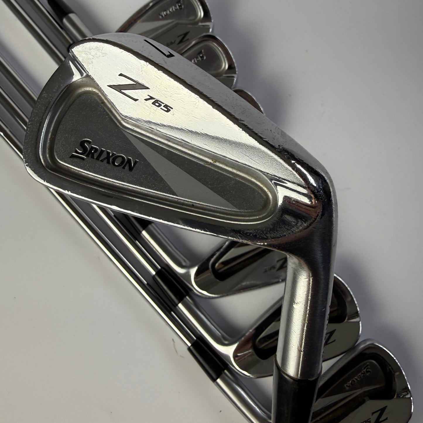 Set of golf clubs with 'Srixon' branding on a light gray background
