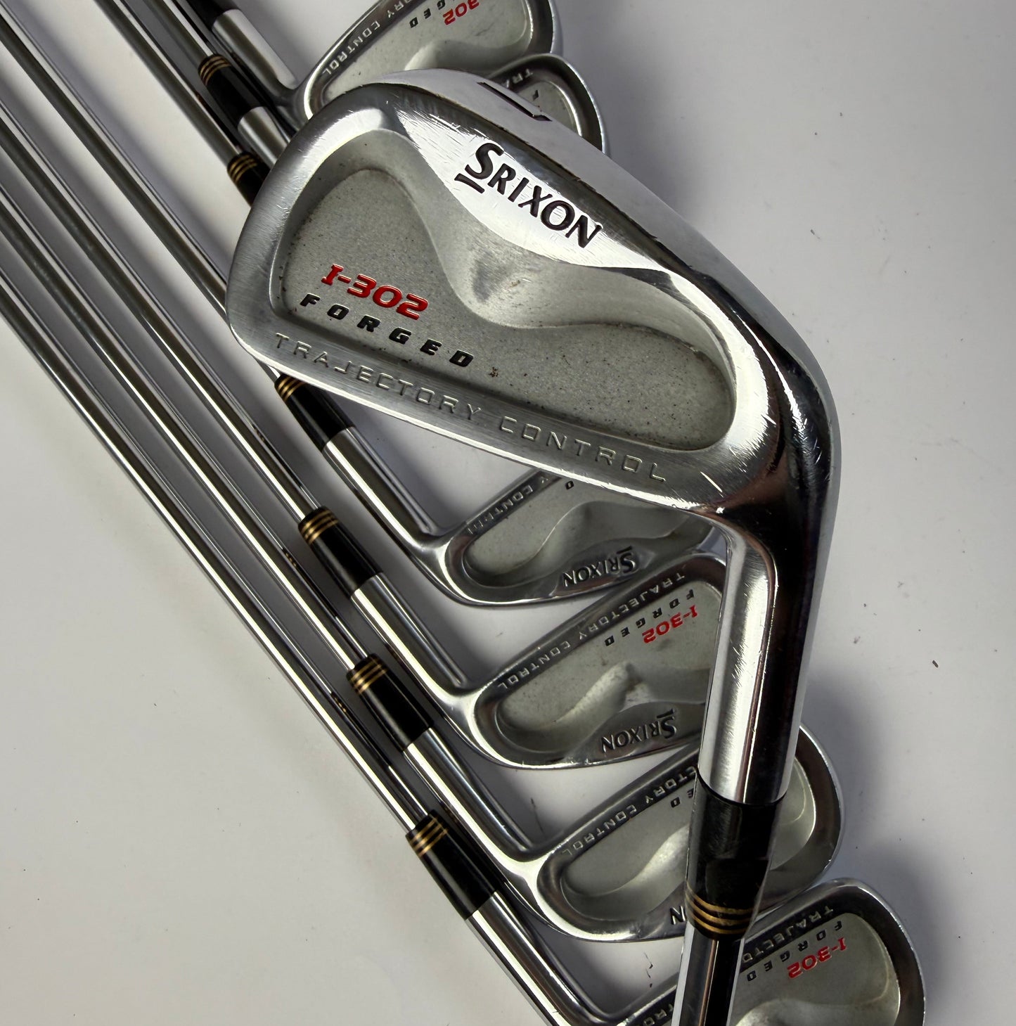 Set of Srixon I-302 Forged iron golf clubs on a white background