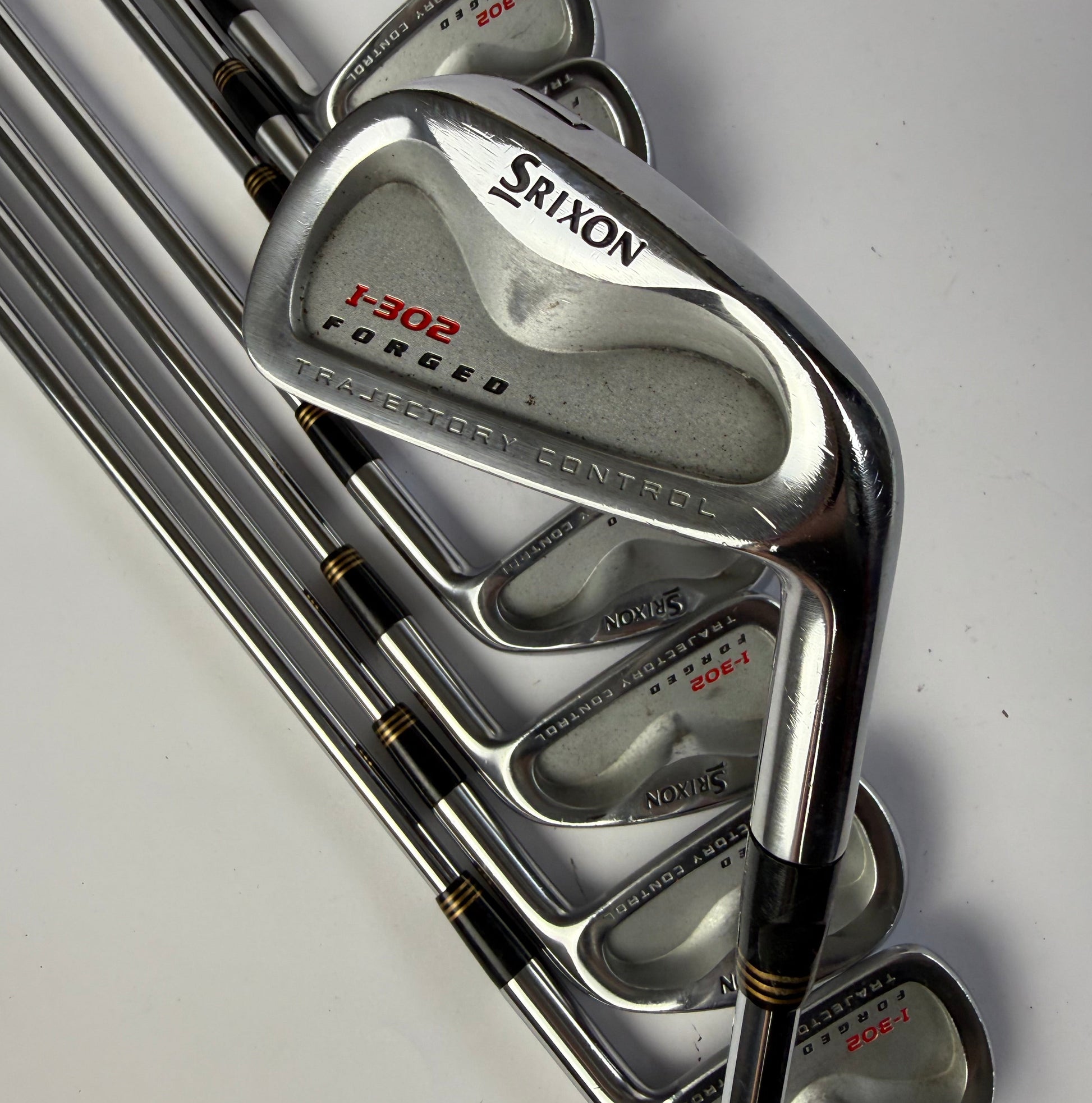 Set of Srixon I-302 Forged iron golf clubs on a white background