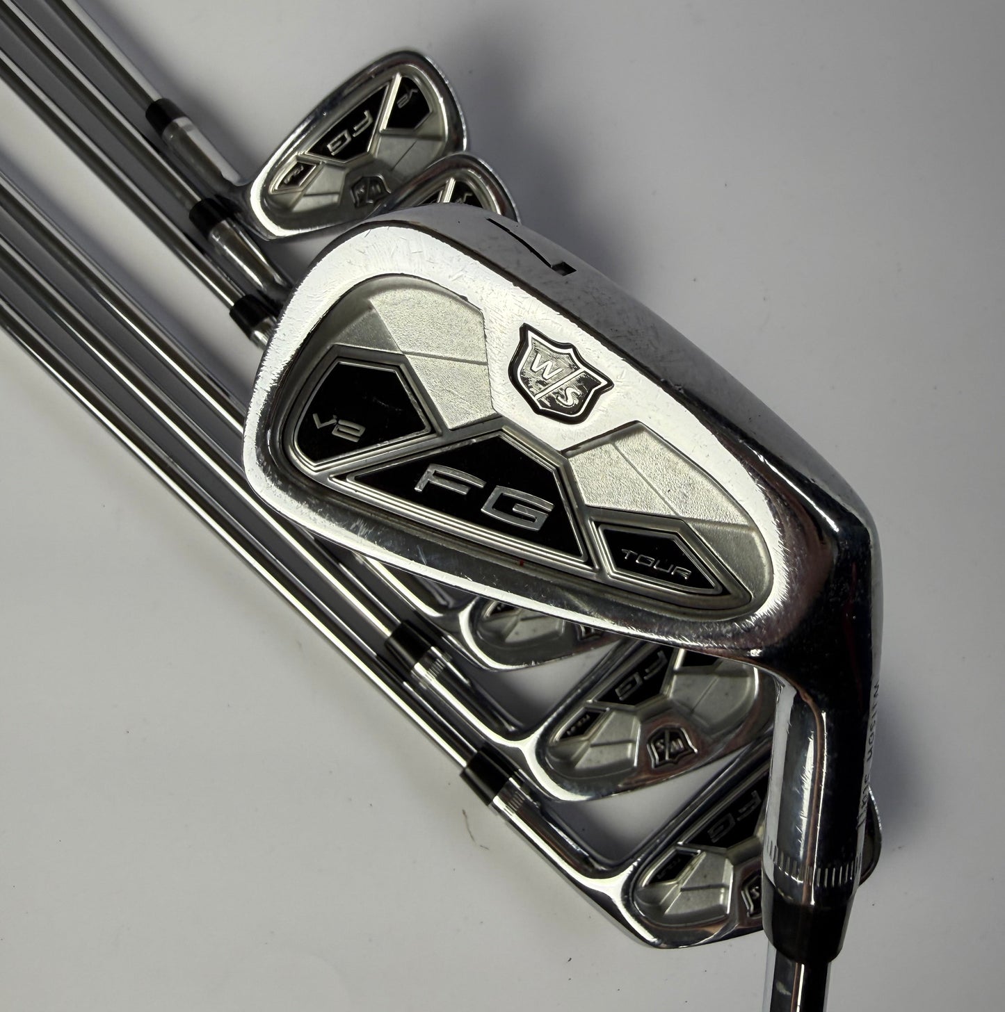 Wilson Staff FG Tour Irons on a gray background