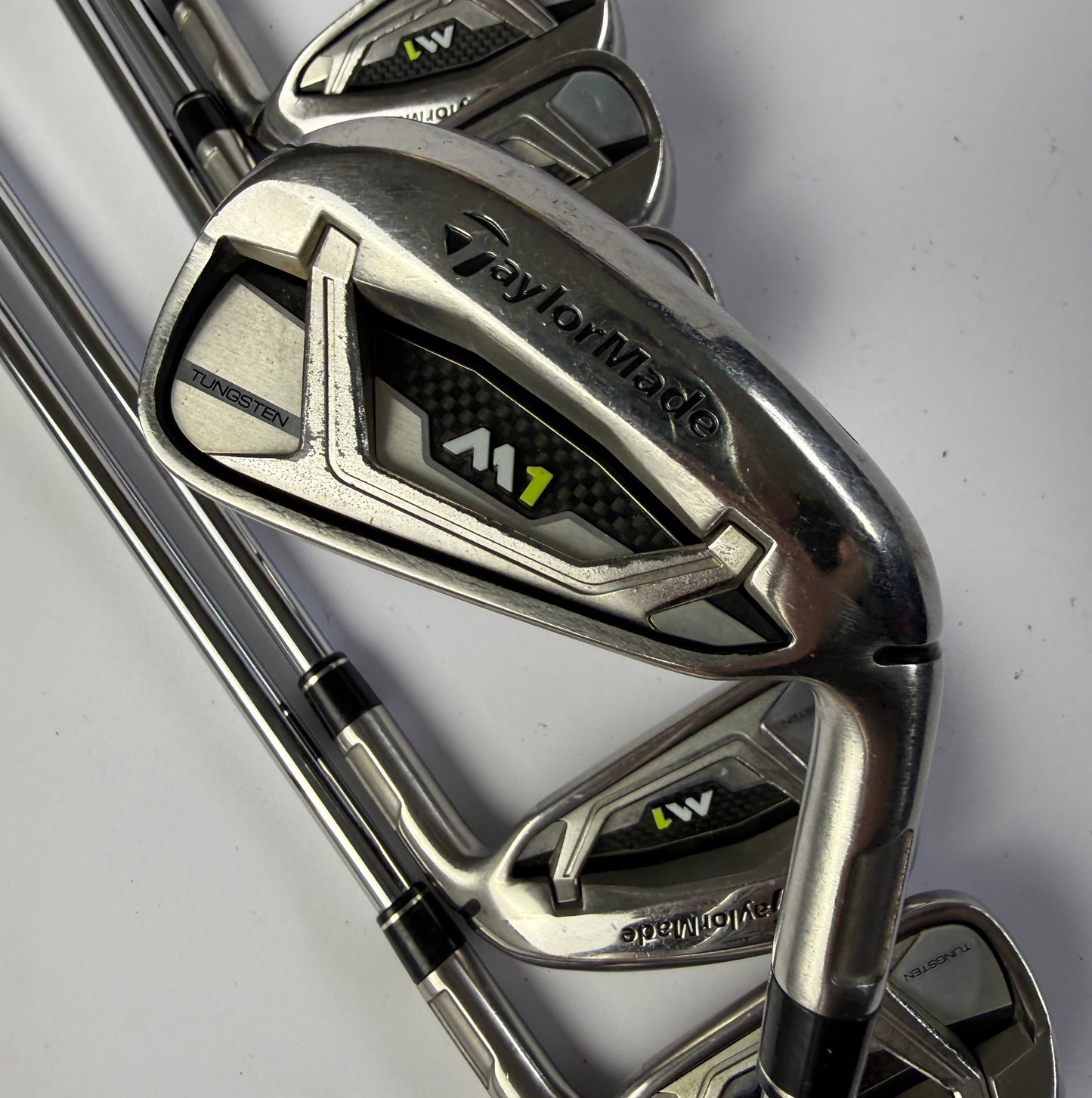 Taylormade M1 irons golf clubs on a light gray background